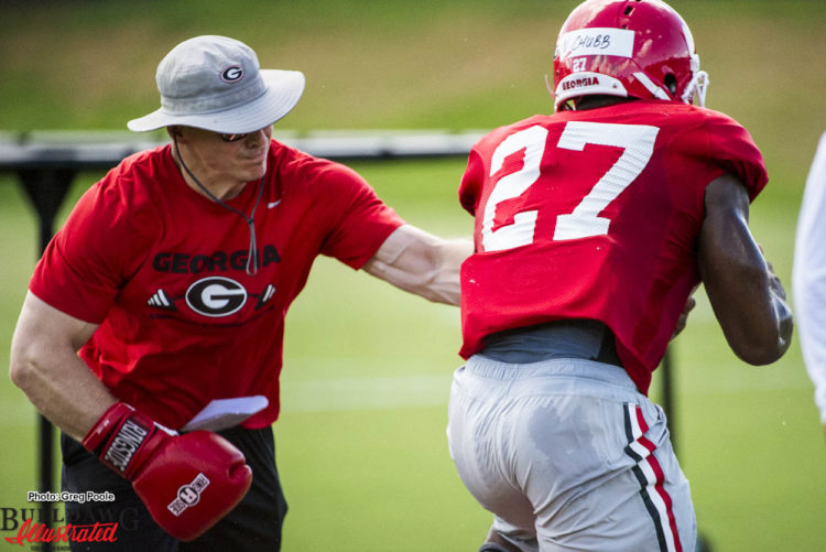 Aaron Feld tries to dislodge ball from Nick Chubb