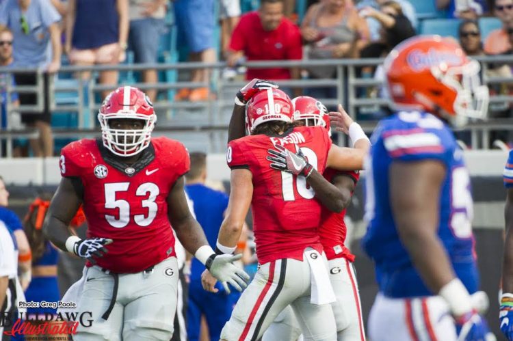 Quarterback Jacob Eason celebrates with a teammate after throwing a TD