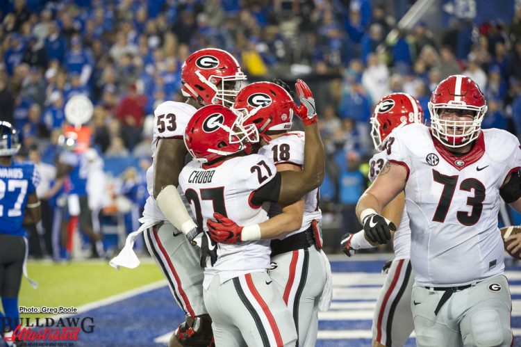 Nick Chubb (27) and Lamont Gaillard (53) celebrate with Isaac Nauta (18)