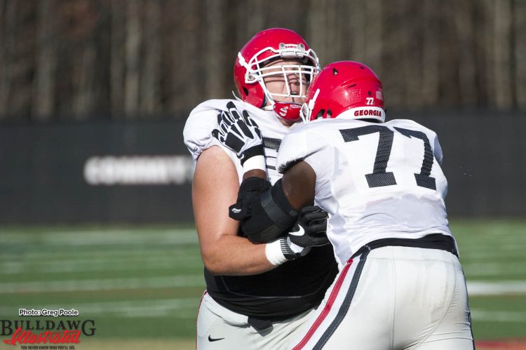 Isaiah Wynn (77) practices a blocking technique on fellow teammate