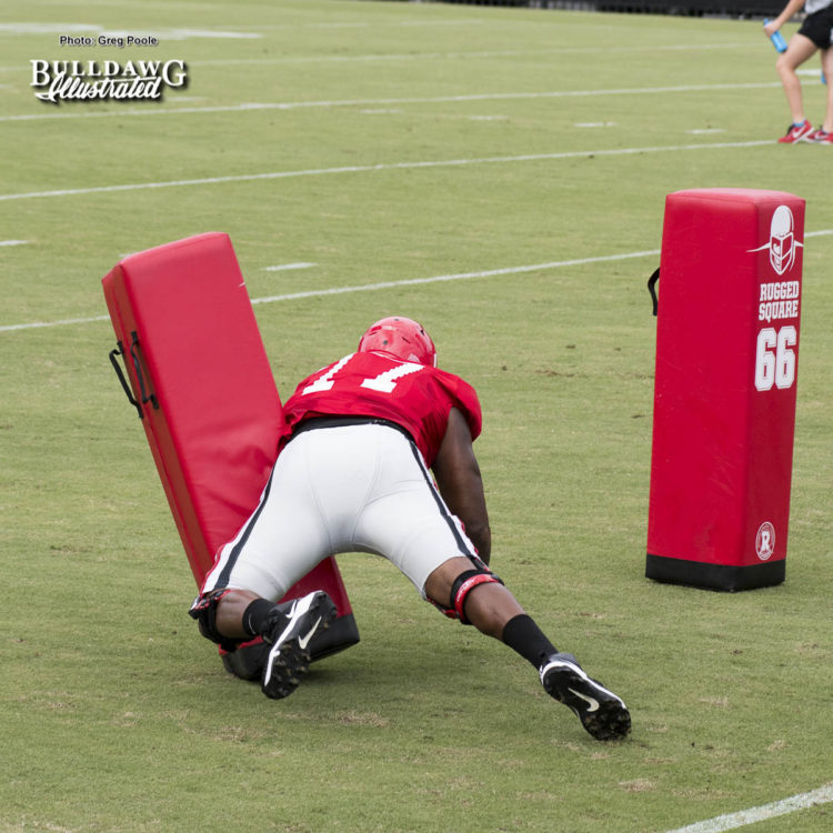 Isaiah Wynn practicing cut block on dummy.