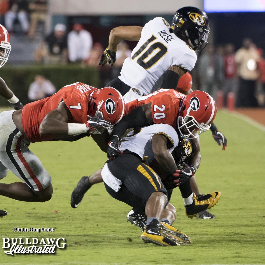 Lorenzo Carter (7) and J.R. Reed (20) stuff a Missouri ballcarrier